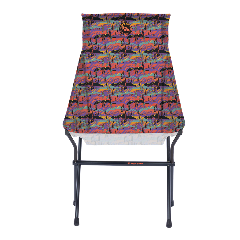 The Big Agnes Returns Big Six Camp Chair - Alpenglow is a lightweight, packable camp chair with a black metal frame and a colorful seat featuring a vibrant abstract mountain landscape in red, purple, blue, and orange.