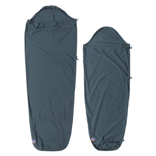 Two dark blue Big Agnes Cotton Sleeping Bag Liners are laid flat. The left is rectangular with a hood; the right is a tapered mummy style. Both feature a small logo at the bottom and are ideal for travel.