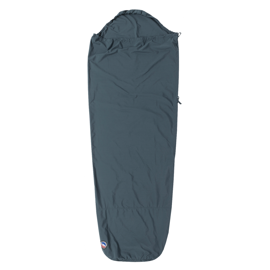 The Big Agnes Cotton Sleeping Bag Liner features a dark gray, mummy-style design with a hood, tapering toward the bottom, and a small logo near the foot—laid flat on white. Ideal for travel comfort.
