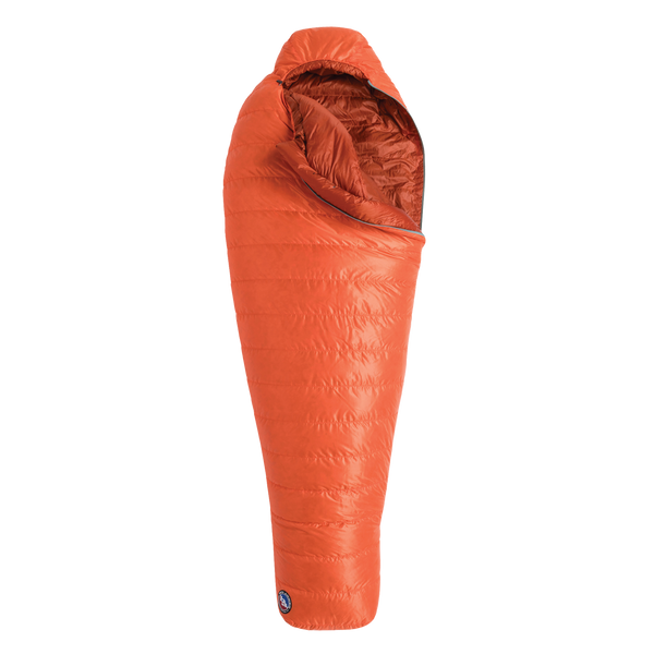 The Big Agnes Returns Greystone 20° is an orange, mummy-style sleeping bag with a hood and DownTek insulation, designed for warm backpacking trips, shown upright against a white background.