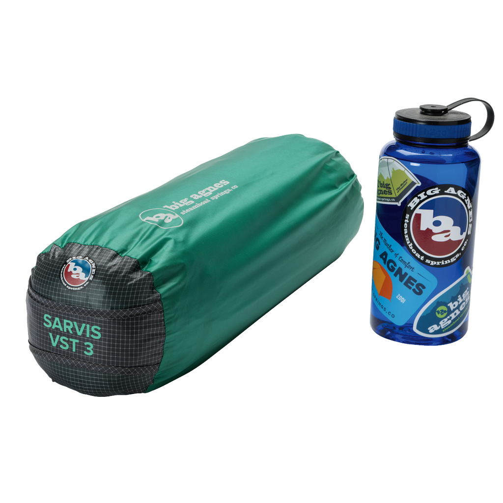 A green, cylindrical Big Agnes Returns Sarvis VST 3 tent bag made with Hyperbead fabric is next to a blue Big Agnes Returns water bottle with outdoor stickers on a white background.