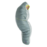 A person stands upright, fully zipped inside the Big Agnes Sidewinder 0˚ sleeping bag in gray and light green, featuring body-mapped insulation with only their face visible.