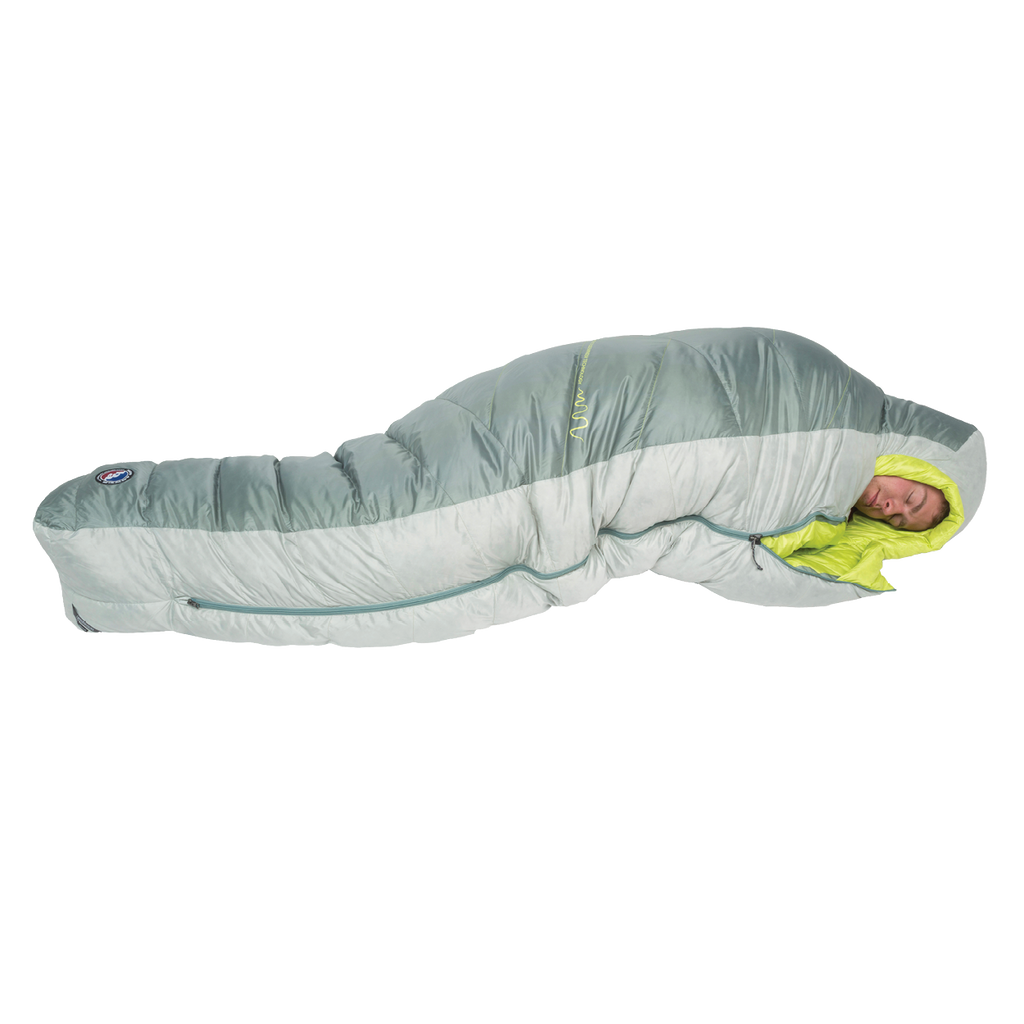 A person is sleeping inside the Big Agnes Returns Sidewinder 0˚, a light gray and lime green mummy-style side sleeper sleeping bag with body-mapped insulation, fully zipped and snug around them, as they rest on a white background.