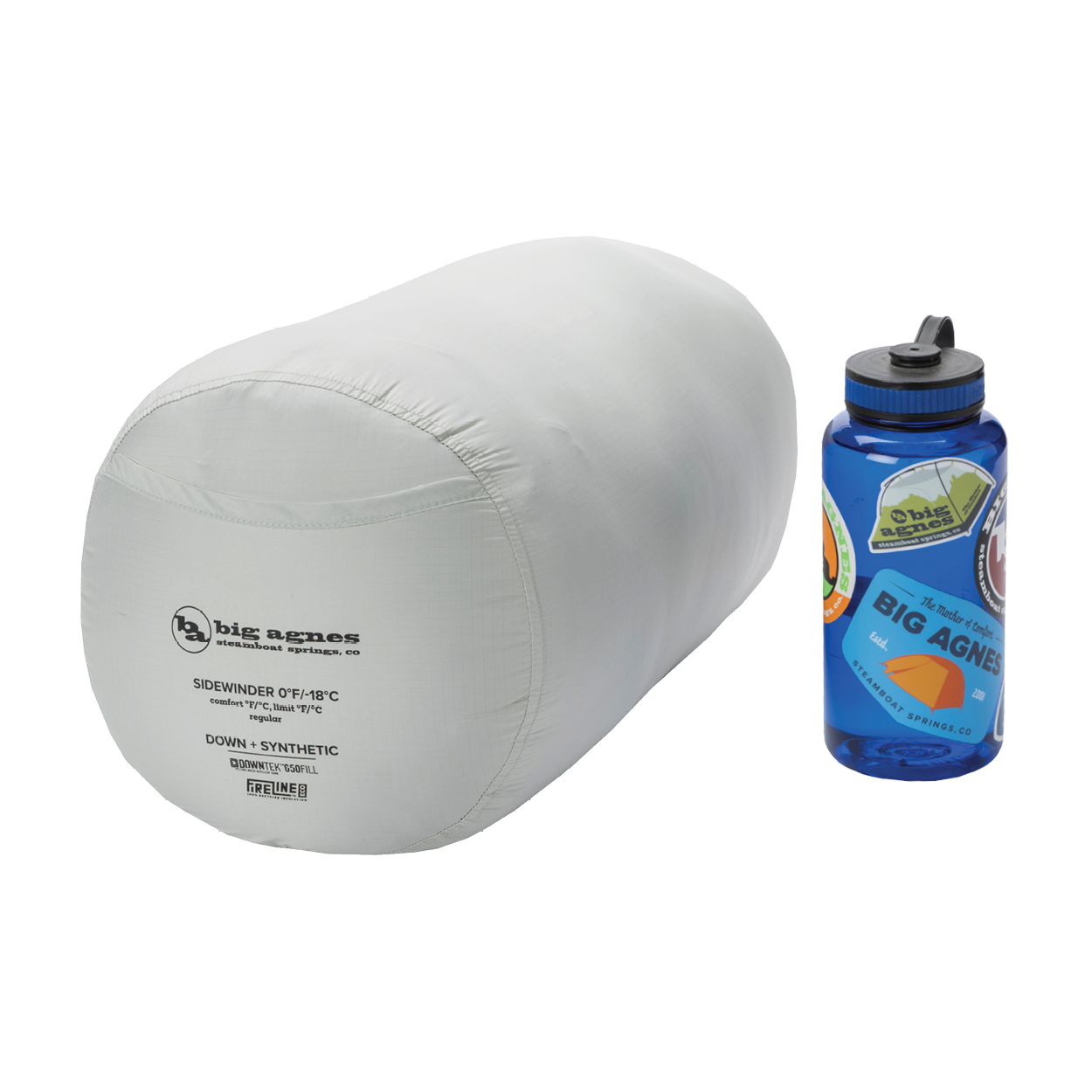 A light gray Big Agnes Sidewinder 0˚ sleeping bag with body-mapped insulation, packed in a cylindrical stuff sack, sits next to a blue sticker-covered Nalgene bottle on a white background.