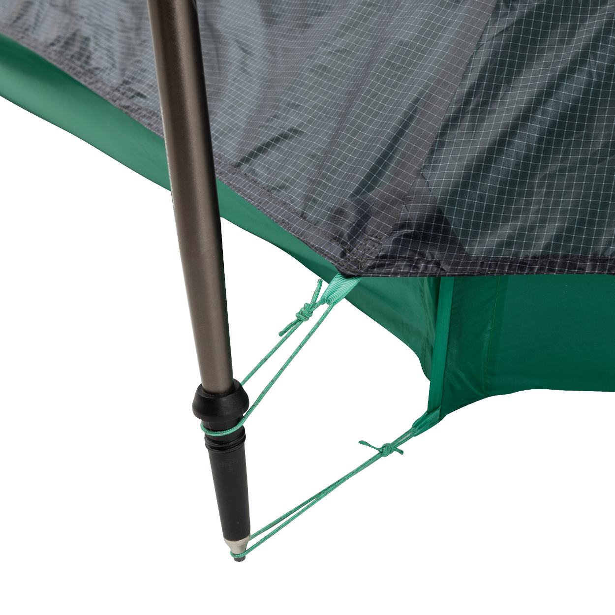 Close-up of a String Ridge VST 1.5 tent corner by Big Agnes, showing a black pole secured with green guy lines on reinforced, grid-patterned green and gray fabric—highlighting this ultralight shelter’s durability and detailed design.