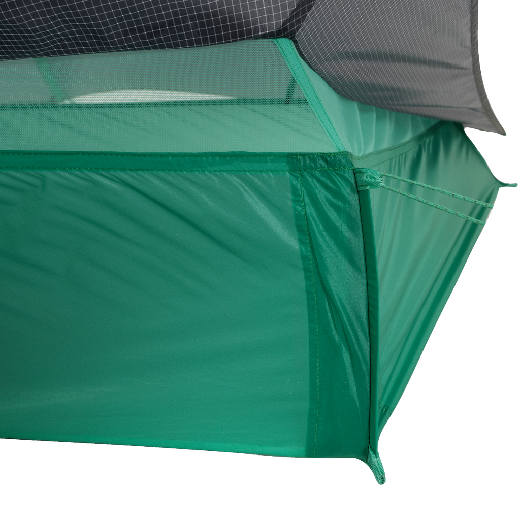 Close-up of the corner of the Big Agnes Returns String Ridge VST 1.5 tent, an ultralight shelter featuring mesh upper panels, solid green lower fabric, and precise stitching that showcases its quality construction.