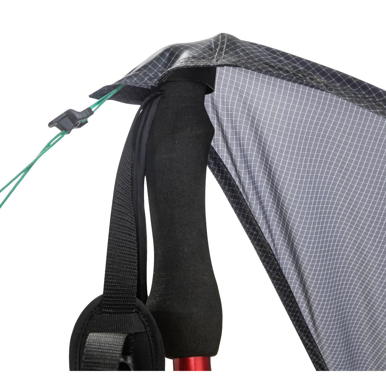 Close-up of the Big Agnes Returns String Ridge VST 1.5, with a trekking pole supporting the tent’s black and gray fabric corner, black strap, and green guyline with a plastic tensioner in this ultralight shelter setup.