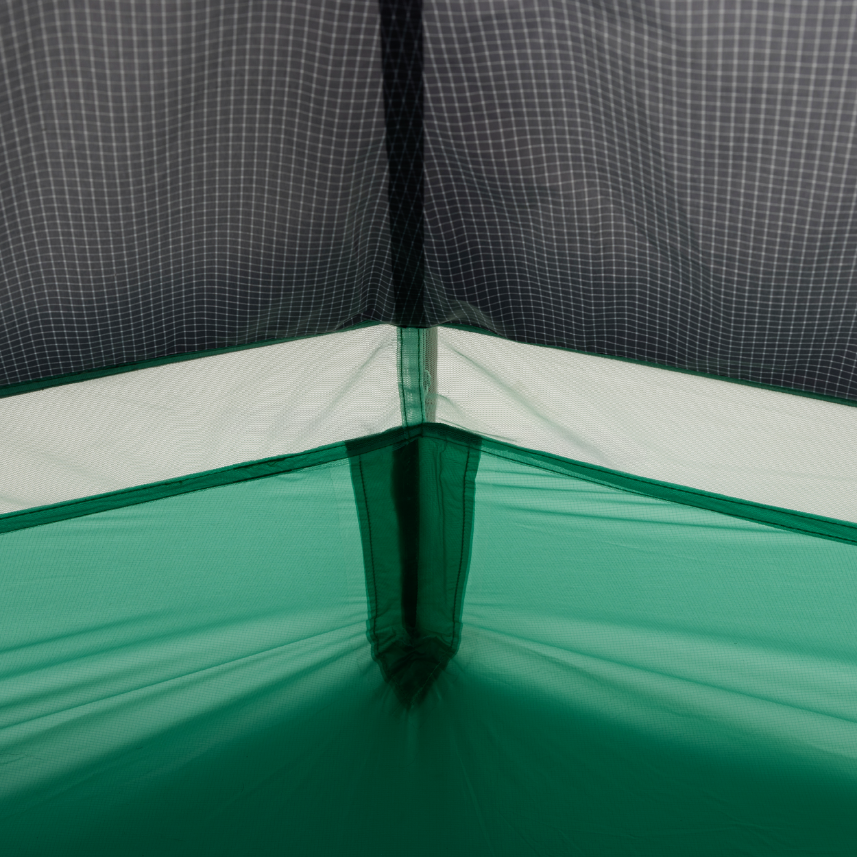 Close-up of the inside corner of the Big Agnes Returns String Ridge VST 1.5 tent, showing intersecting seams and mesh netting. The green geometric fabric highlights this ultralight shelter’s innovative design.