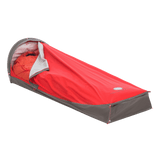 The Big Agnes Three Wire Hooped Bivy in red and gray, shown partially open to reveal a matching red sleeping bag, provides four-season protection—perfect for outdoor camping, minimalist shelter, or emergency use.