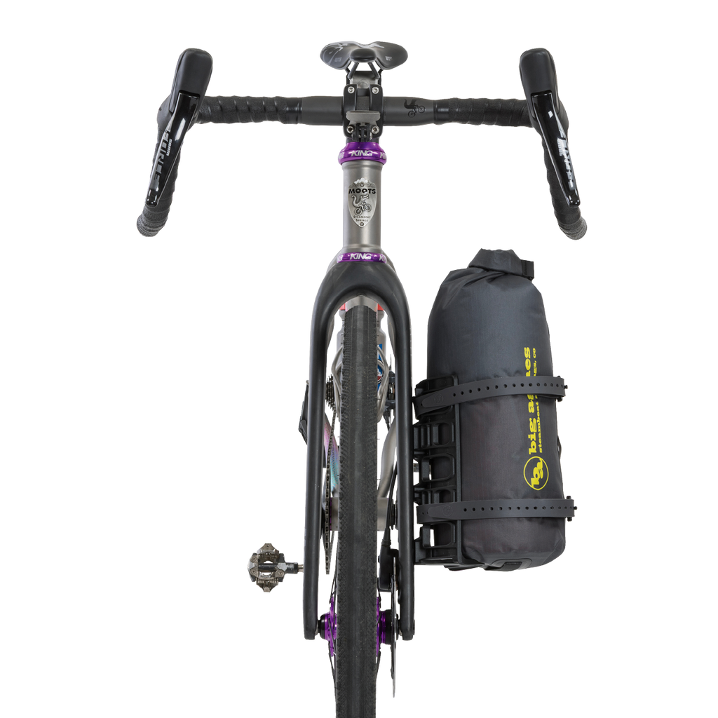 Bicycle with a black Tiger Wall UL Bikepack attached to the back on a white background