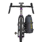 Bicycle with a black Tiger Wall UL Bikepack attached to the back on a white background