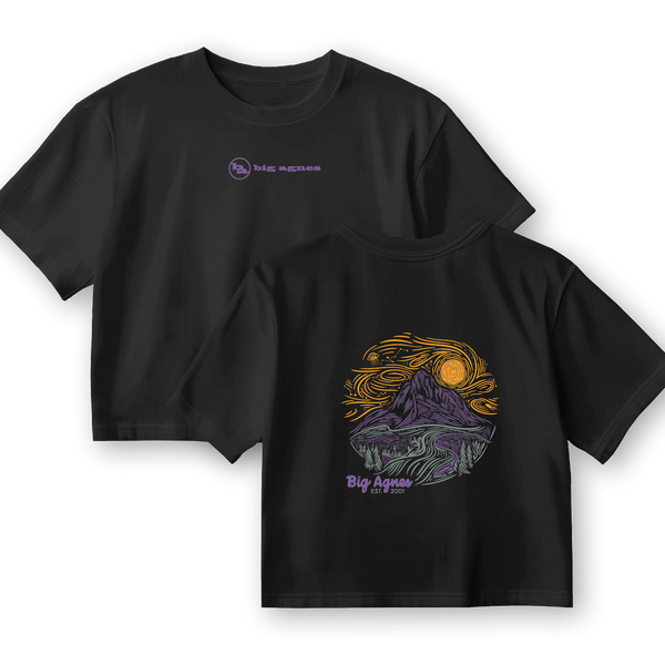 The W's Cosmic Sky T-Shirt by Big Agnes Returns features a small front logo and a bold Cosmic Sky mountain, river, and sky graphic with “Big Agnes Returns EST 2000” on the back. This black, limited edition tee is perfect for outdoor enthusiasts.