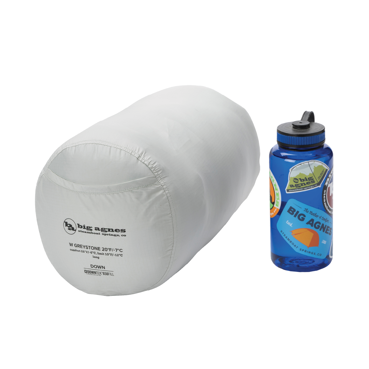 A packed Big Agnes Women's Greystone 30° sleeping bag is shown next to a blue Nalgene water bottle for size comparison, both placed on a plain white background.