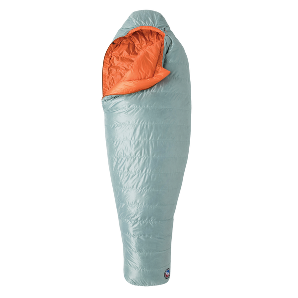 The Big Agnes Returns Women's Greystone 30° sleeping bag in light blue, featuring DownTek insulation, stands upright against a white background. Its mummy-style hood is slightly open, showing the bright orange interior lining.
