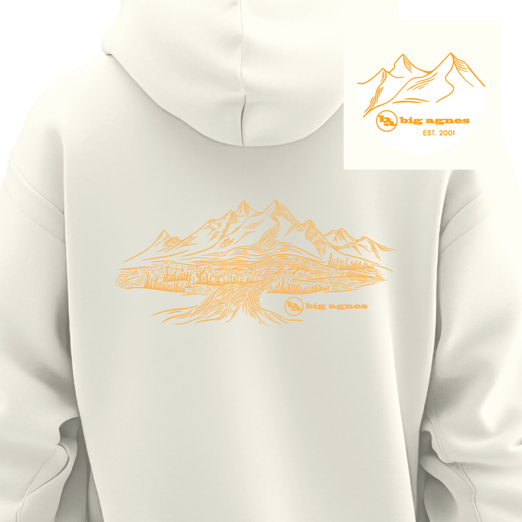 White hoodie with orange mountain graphic and 'Big Agnes Returns' logo on a white background